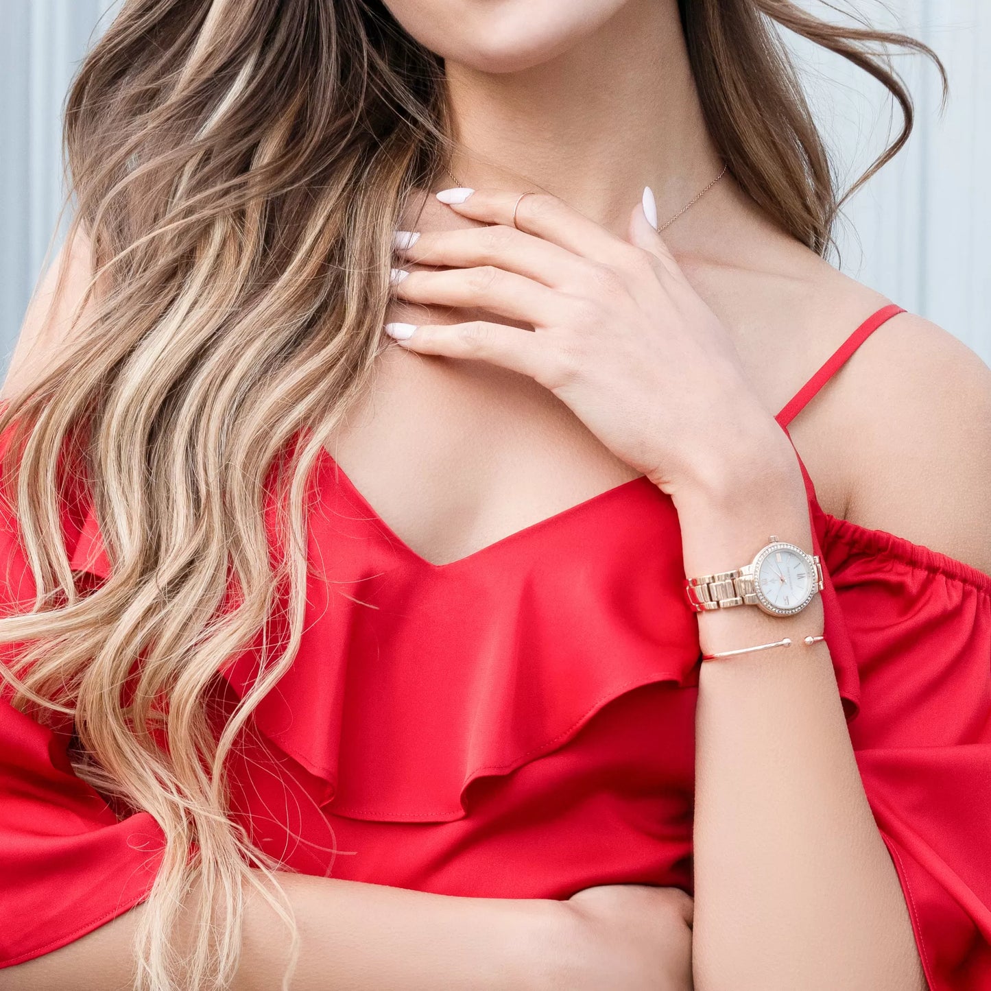 Model wearing Monarchic® Watch - Cosmopolitan - Carrie Edition - Rose Gold link women's watch and rose gold accessories with red jumpsuit